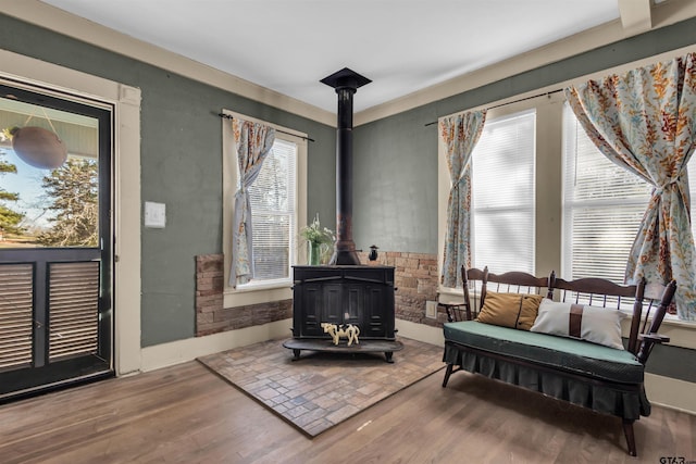 sitting room with hardwood / wood-style floors and a wood stove