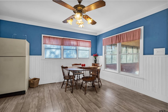 dining space with ceiling fan, crown molding, and hardwood / wood-style flooring