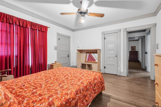 bedroom with hardwood / wood-style floors, ceiling fan, and crown molding