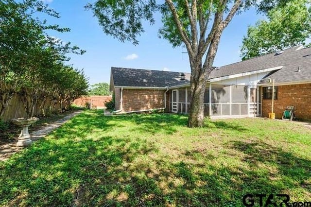 back of house with a sunroom and a yard