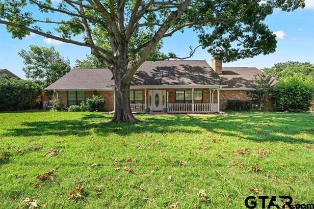 view of front facade featuring covered porch and a front lawn