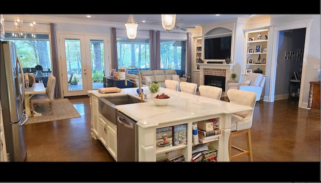 kitchen featuring appliances with stainless steel finishes, decorative light fixtures, a healthy amount of sunlight, and a breakfast bar area