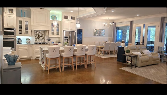 kitchen featuring stainless steel appliances, a center island, tasteful backsplash, pendant lighting, and white cabinetry