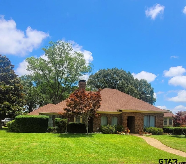 3802 Allendale Dr, Tyler, TX 75701 - ranch-style house with a front yard, a chimney, brick siding, and roof with shingles