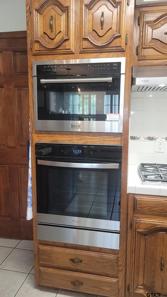 3802 Allendale Dr, Tyler, TX 75701 - kitchen view of wall oven, brown cabinets, and backsplash