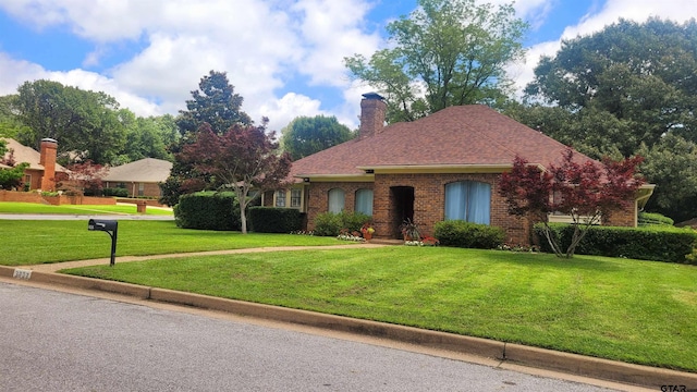 3802 Allendale Dr, Tyler, TX 75701 - view of front of home featuring a front yard, brick siding, a chimney, and a shingled roof