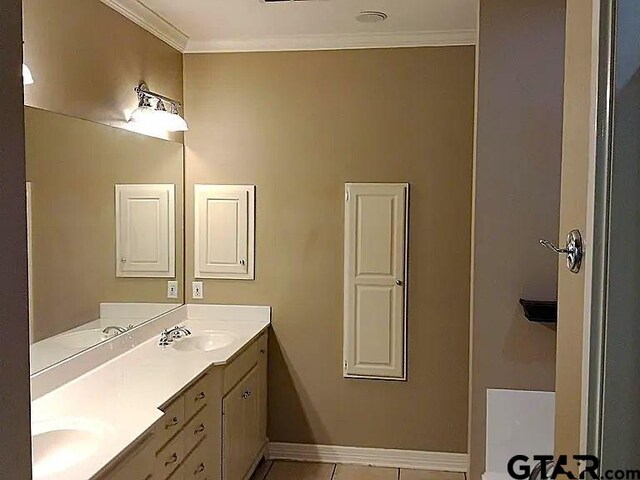 full bath with double vanity, a sink, ornamental molding, and baseboards