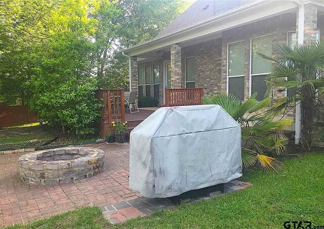 view of patio with an outdoor fire pit and a wooden deck