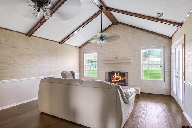 living room with a fireplace, a wealth of natural light, ceiling fan, and dark hardwood / wood-style floors