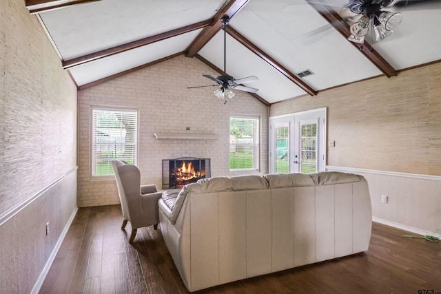 unfurnished living room with french doors, dark hardwood / wood-style floors, ceiling fan, a fireplace, and lofted ceiling with beams