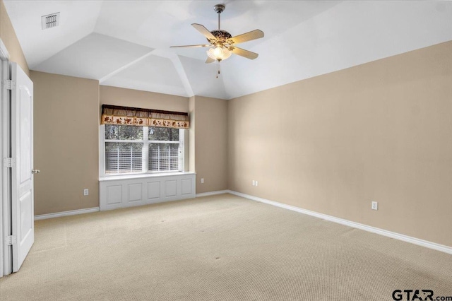 empty room featuring vaulted ceiling, baseboards, visible vents, and light colored carpet