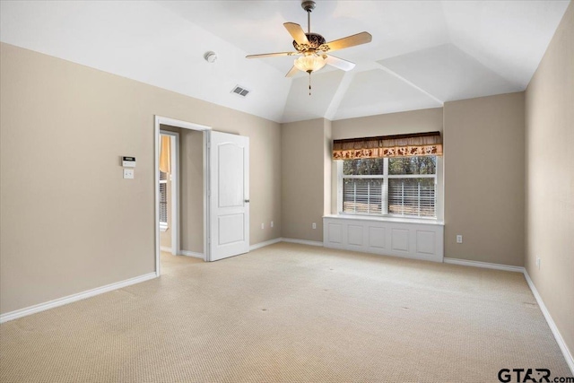 unfurnished room with lofted ceiling, baseboards, a ceiling fan, and light colored carpet