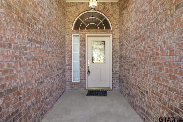 view of exterior entry with brick siding