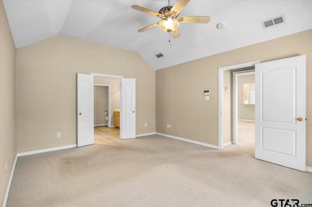 unfurnished bedroom with lofted ceiling, baseboards, visible vents, and light colored carpet