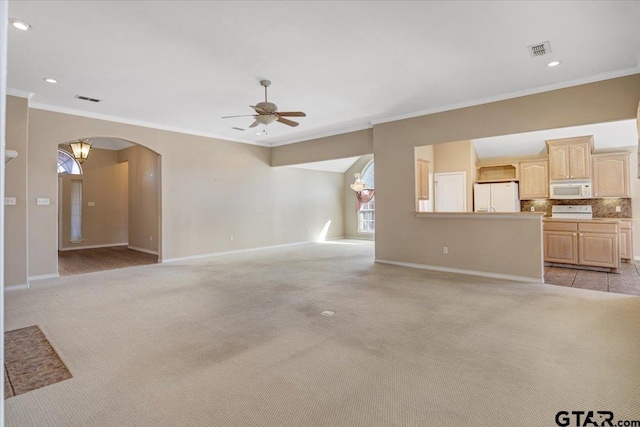 unfurnished living room with arched walkways, light carpet, visible vents, and baseboards