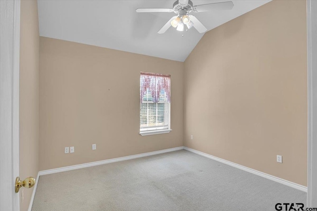 carpeted spare room with lofted ceiling, a ceiling fan, and baseboards