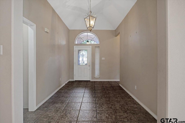 entrance foyer with lofted ceiling, a notable chandelier, and baseboards