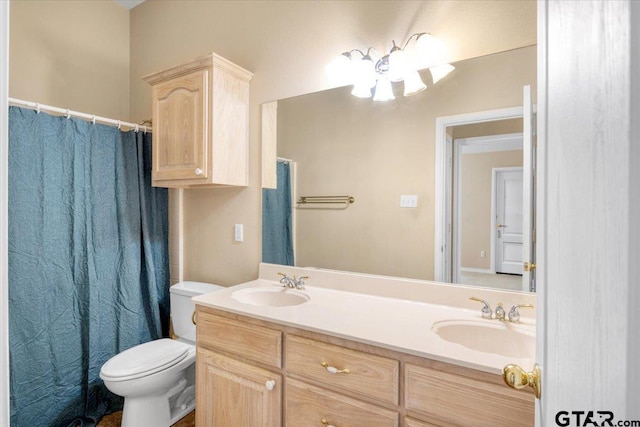 full bathroom with double vanity, a sink, and toilet