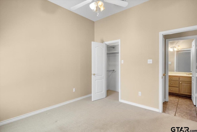 unfurnished bedroom featuring baseboards, a ceiling fan, light colored carpet, a spacious closet, and a closet