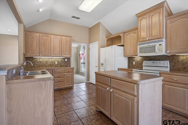 kitchen featuring lofted ceiling, visible vents, light brown cabinetry, a sink, and white appliances