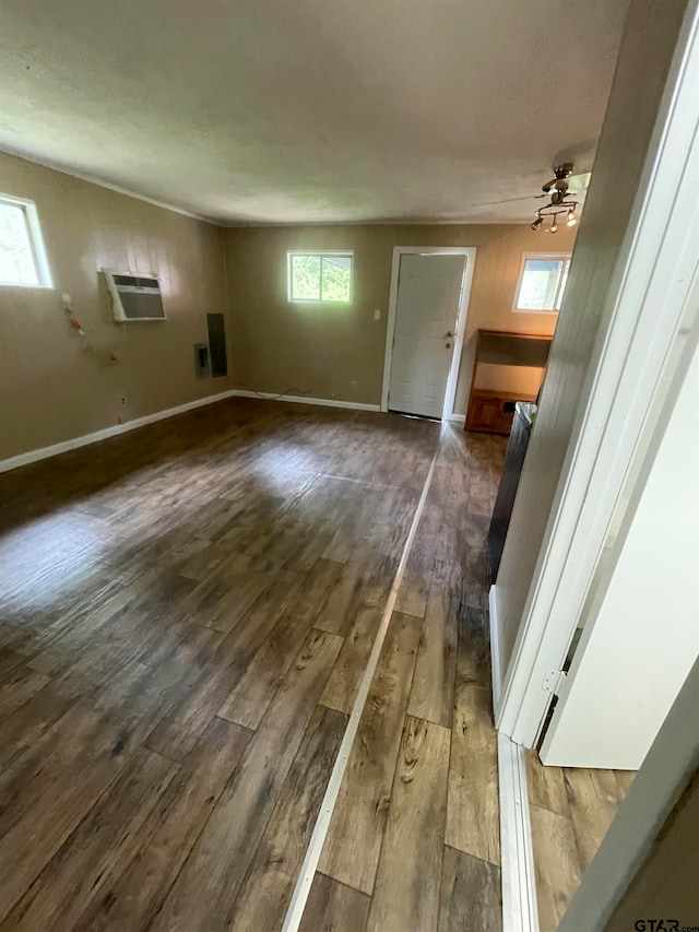 unfurnished living room featuring ceiling fan, plenty of natural light, and dark hardwood / wood-style flooring