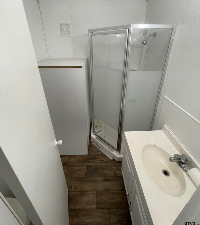 bathroom featuring vanity, hardwood / wood-style floors, and a shower with door