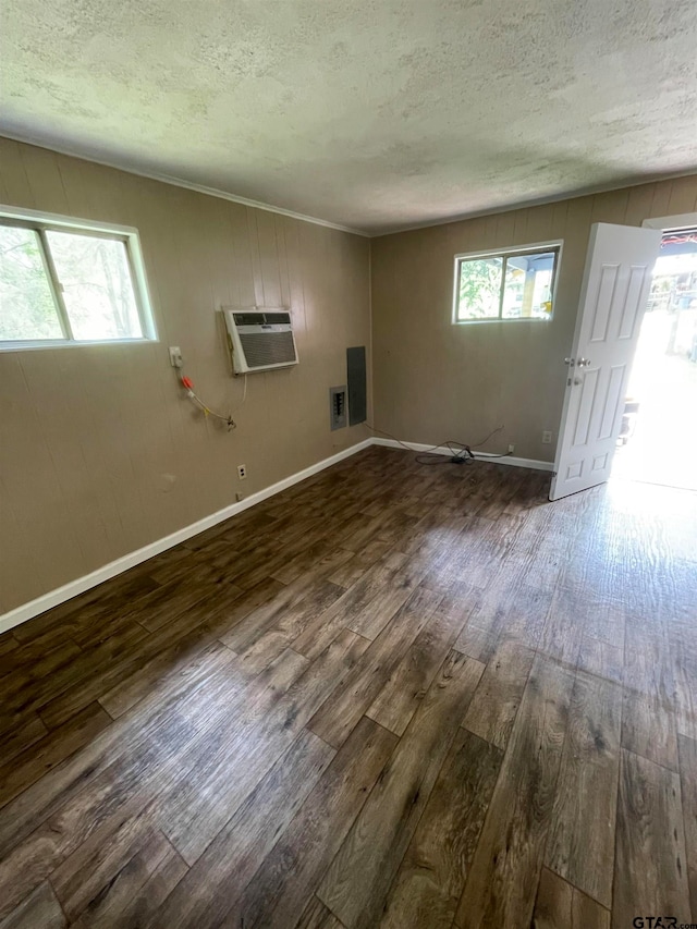 unfurnished room with dark wood-type flooring, plenty of natural light, and a textured ceiling