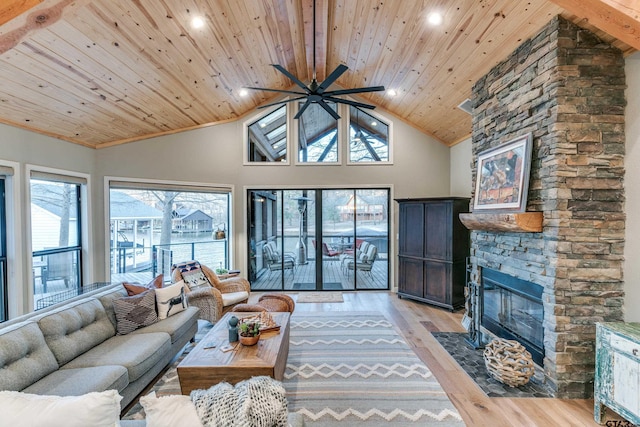 living area with wood ceiling, beam ceiling, a stone fireplace, light wood-style flooring, and high vaulted ceiling