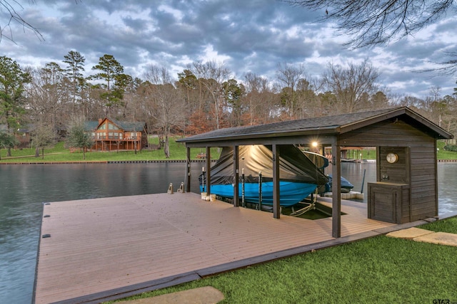 view of dock with a yard, a water view, and boat lift