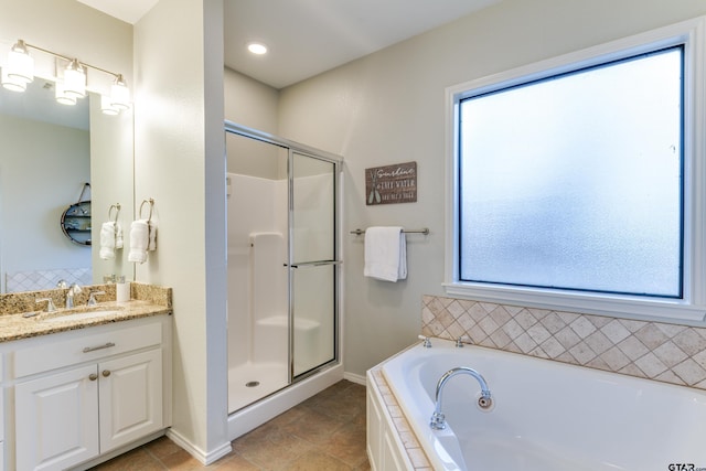 bathroom with a bath, a shower stall, tile patterned floors, and vanity