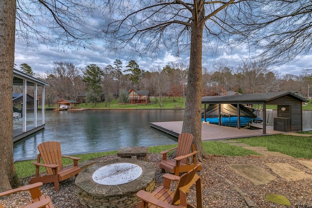 view of patio with an outdoor fire pit, boat lift, a water view, and a boat dock