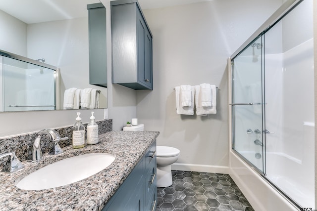 full bath featuring tile patterned floors, baseboards, toilet, enclosed tub / shower combo, and vanity