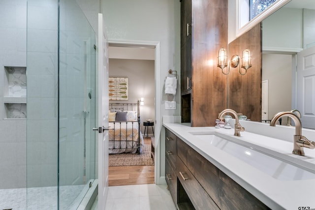 ensuite bathroom with a tile shower, tile patterned floors, ensuite bath, and vanity