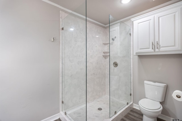 bathroom featuring a shower stall, toilet, and baseboards