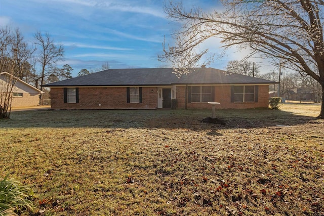 back of property with brick siding and a lawn