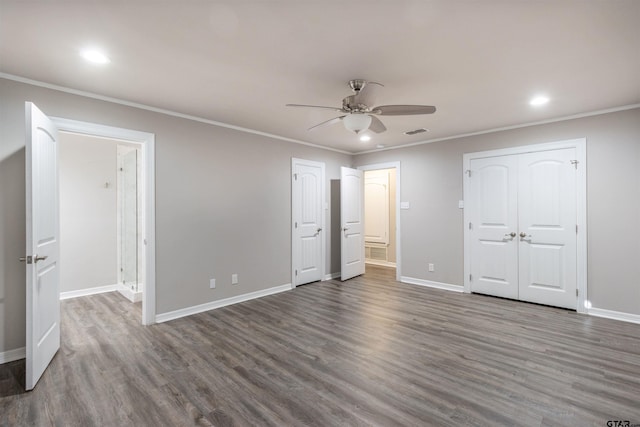 unfurnished bedroom featuring crown molding, wood finished floors, visible vents, and baseboards