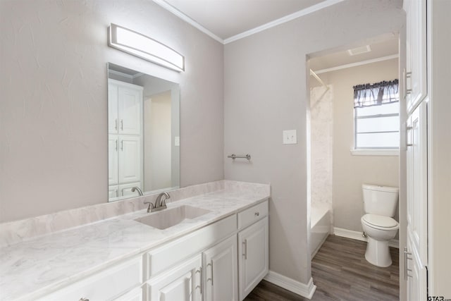 bathroom with baseboards, toilet, ornamental molding, wood finished floors, and vanity