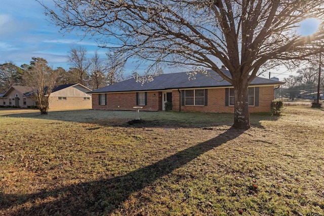 ranch-style house featuring brick siding and a front yard