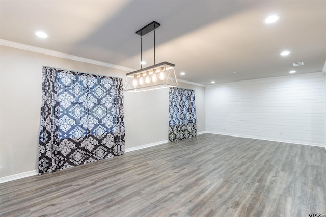 empty room featuring recessed lighting, wood finished floors, visible vents, and ornamental molding