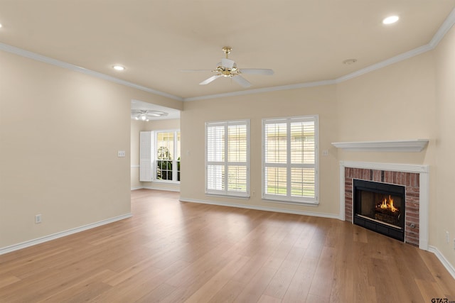 unfurnished living room featuring crown molding, light hardwood / wood-style floors, a fireplace, and ceiling fan