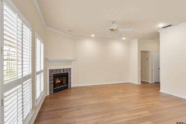 unfurnished living room featuring ceiling fan, light hardwood / wood-style floors, a brick fireplace, and ornamental molding