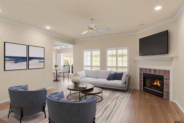 living room with light hardwood / wood-style flooring, ornamental molding, and a fireplace