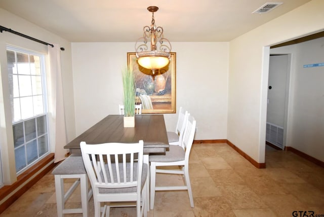 dining area featuring visible vents, baseboards, and a notable chandelier