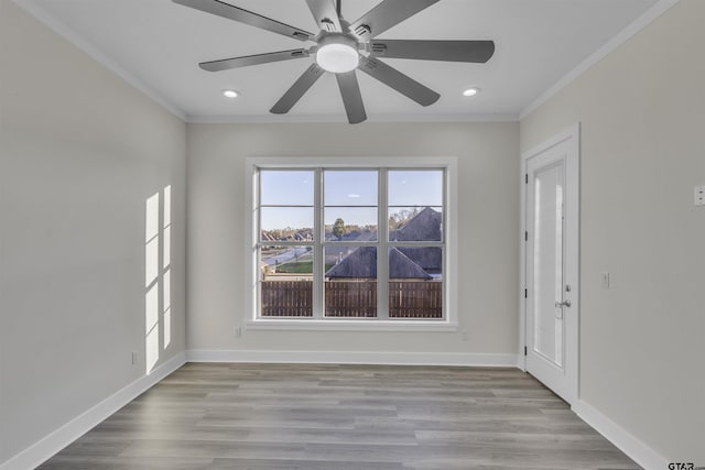 spare room featuring light wood-type flooring, ceiling fan, and crown molding