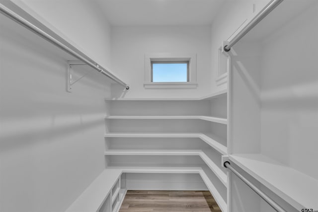 walk in closet with hardwood / wood-style floors