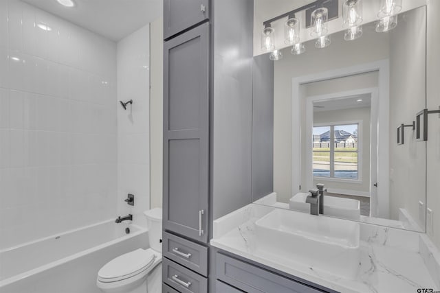 full bathroom featuring vanity, tiled shower / bath combo, and toilet