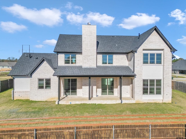 back of property with a patio area and a lawn