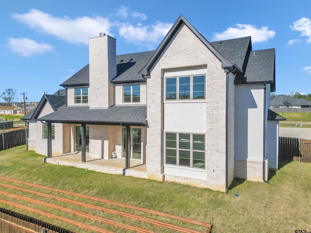 back of house with a lawn and a patio