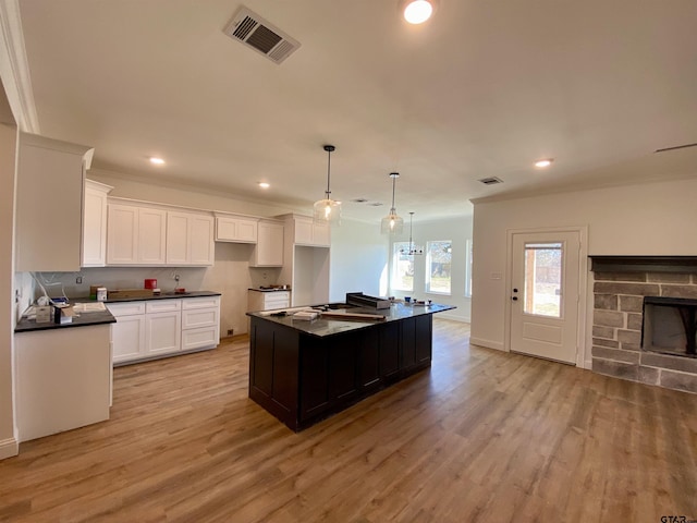 kitchen featuring light wood-style floors, visible vents, dark countertops, and white cabinets