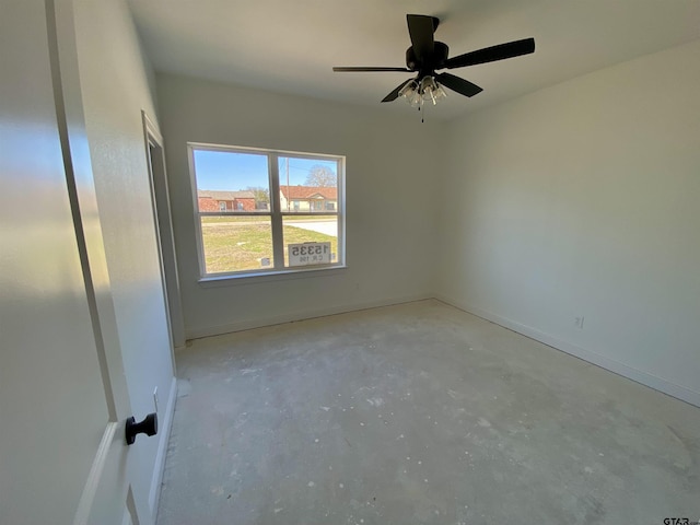 empty room featuring baseboards, concrete flooring, and ceiling fan